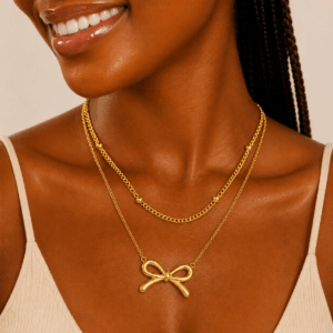 Stainless steel layered bow pendant necklace available in gold and silver
