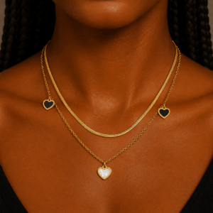 Gold layered necklace with snake chain and black and pearl heart charms